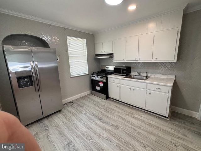 4066 Creston St, Philadelphia, PA 19135 - kitchen featuring appliances with stainless steel finishes, ornamental molding, light countertops, white cabinetry, and light wood-style floors