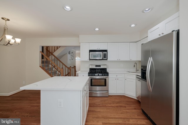 6110 Joust Ln, Alexandria, VA 22315 - kitchen featuring stainless steel appliances, a chandelier, white cabinets, pendant lighting, and light stone counters