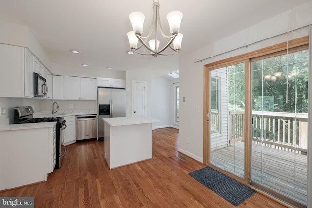 6110 Joust Ln, Alexandria, VA 22315 - kitchen featuring appliances with stainless steel finishes, a chandelier, a center island, white cabinets, and wood finished floors