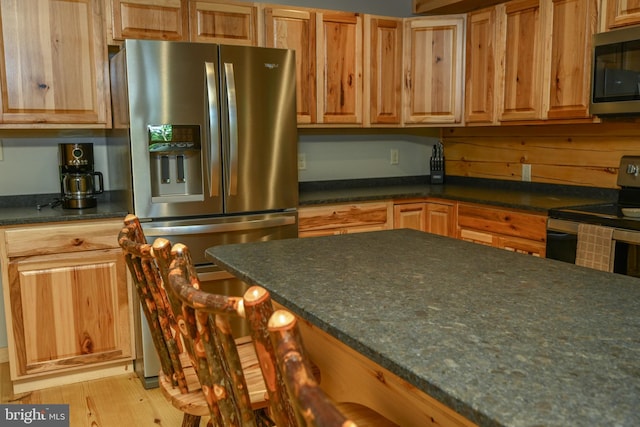 118 Sandstone, Mc Henry, MD 21541 - kitchen featuring stainless steel appliances, light wood-type flooring, and a kitchen bar