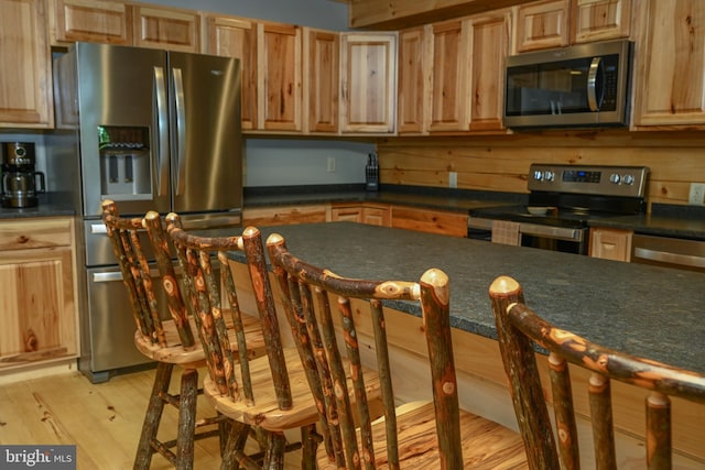 118 Sandstone, Mc Henry, MD 21541 - kitchen featuring stainless steel appliances, dark countertops, light wood-type flooring, a kitchen breakfast bar, and light brown cabinets