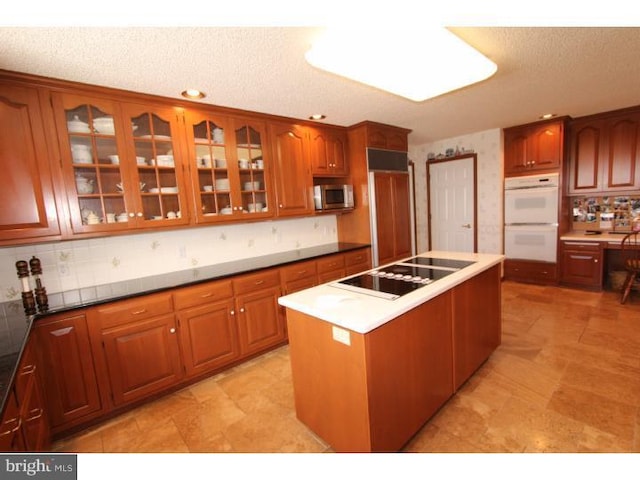 540 Hain Rd, Sinking Spring, PA 19608 - kitchen with double oven, stainless steel microwave, paneled refrigerator, black electric cooktop, and a center island