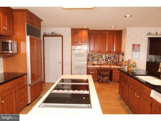 540 Hain Rd, Sinking Spring, PA 19608 - kitchen featuring white double oven, stainless steel microwave, wallpapered walls, black electric stovetop, and paneled refrigerator