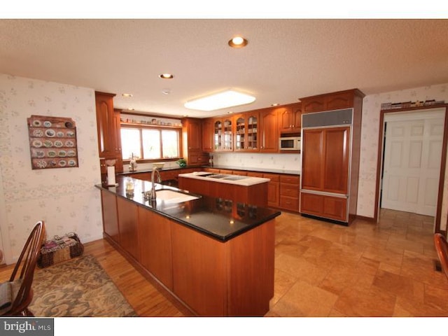 540 Hain Rd, Sinking Spring, PA 19608 - kitchen with wallpapered walls, a peninsula, paneled built in refrigerator, white microwave, and brown cabinetry