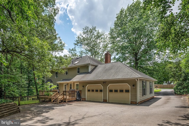 15 Tally Ho Dr, Fredericksburg, VA 22405 - view of front of house with roof with shingles, driveway, a wooden deck, a chimney, and an attached garage