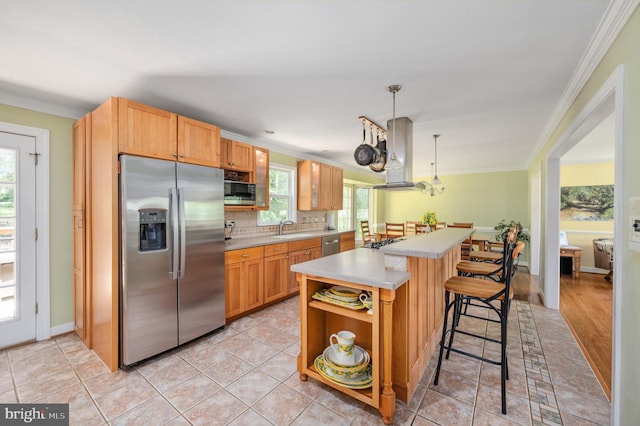 15 Tally Ho Dr, Fredericksburg, VA 22405 - kitchen featuring appliances with stainless steel finishes, extractor fan, ornamental molding, light countertops, and a kitchen breakfast bar