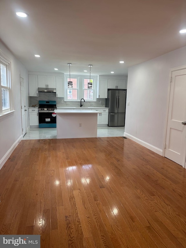 1333 Friendship St, Philadelphia, PA 19111 - kitchen with stainless steel appliances, under cabinet range hood, light countertops, white cabinets, and a kitchen island