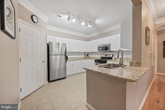 7 Booth St Unit 202, Gaithersburg, MD 20878 - kitchen with appliances with stainless steel finishes, a peninsula, light stone countertops, white cabinetry, and ornamental molding