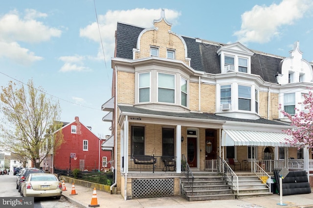 452 W King St, York, PA 17401 - view of front facade featuring covered porch, roof with shingles, brick siding, and mansard roof