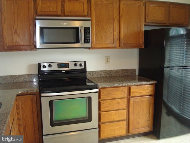 1704 Stoneham Dr, West Chester, PA 19382 - kitchen featuring appliances with stainless steel finishes, brown cabinets, and stone countertops