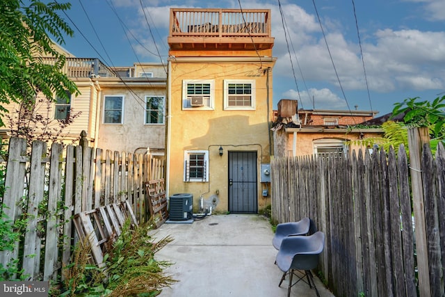 930 Washington Blvd, Baltimore, MD 21230 - rear view of house featuring stucco siding, a fenced backyard, a balcony, and a patio area