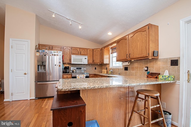 75 Westminster Dr, Front Royal, VA 22630 - kitchen with stainless steel appliances, a peninsula, light wood-type flooring, lofted ceiling, and backsplash