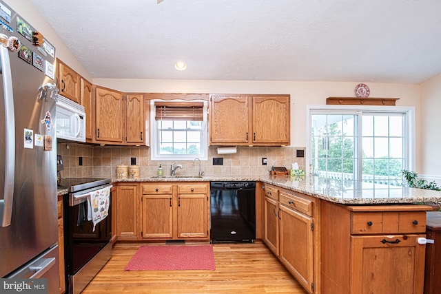 75 Westminster Dr, Front Royal, VA 22630 - kitchen featuring appliances with stainless steel finishes, a peninsula, light wood-style flooring, light stone countertops, and decorative backsplash