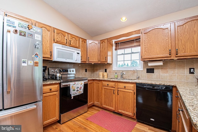 75 Westminster Dr, Front Royal, VA 22630 - kitchen with appliances with stainless steel finishes, lofted ceiling, light wood-style floors, backsplash, and light stone countertops