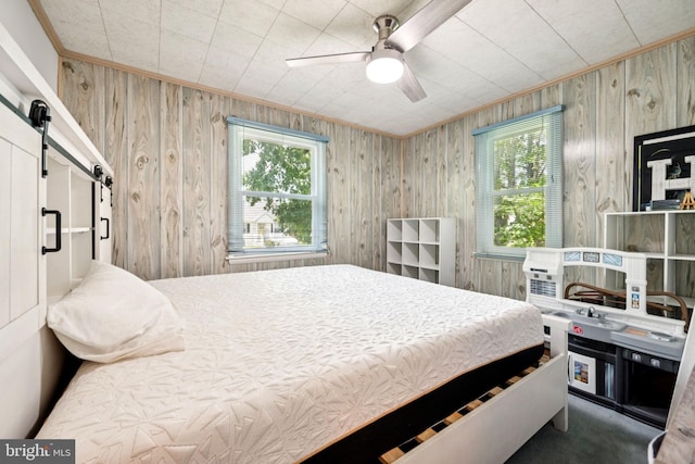 515 N Walnut Ave, Magnolia, NJ 08049 - bedroom with a barn door, wooden walls, ornamental molding, and ceiling fan