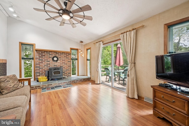 515 N Walnut Ave, Magnolia, NJ 08049 - living area with a wood stove, ceiling fan, lofted ceiling, wood finished floors, and plenty of natural light