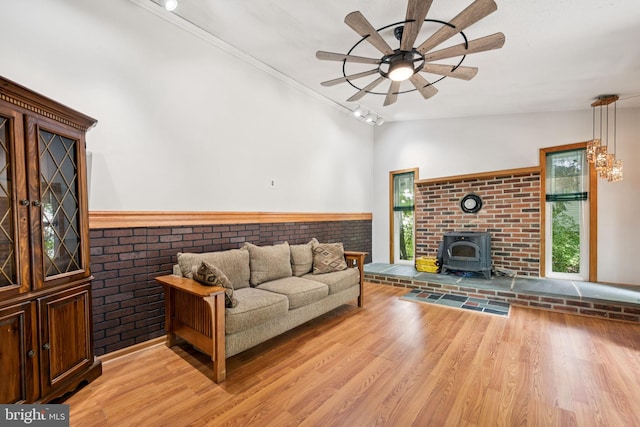 515 N Walnut Ave, Magnolia, NJ 08049 - living area featuring a wood stove, ceiling fan, light wood-type flooring, brick wall, and wainscoting