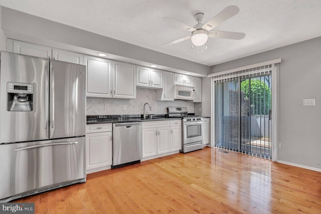 22 Witch Hazel Ct, Monmouth Junction, NJ 08852 - kitchen with stainless steel appliances, dark countertops, light wood finished floors, a textured ceiling, and ceiling fan