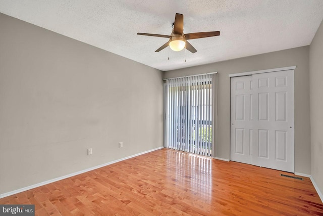 22 Witch Hazel Ct, Monmouth Junction, NJ 08852 - unfurnished bedroom with a textured ceiling, wood finished floors, ceiling fan, and a closet