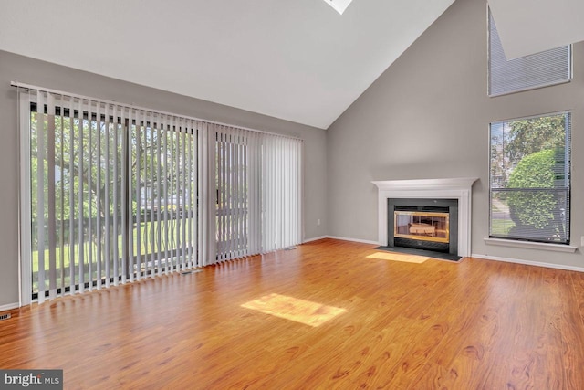 22 Witch Hazel Ct, Monmouth Junction, NJ 08852 - unfurnished living room featuring high vaulted ceiling, wood finished floors, and a fireplace with flush hearth