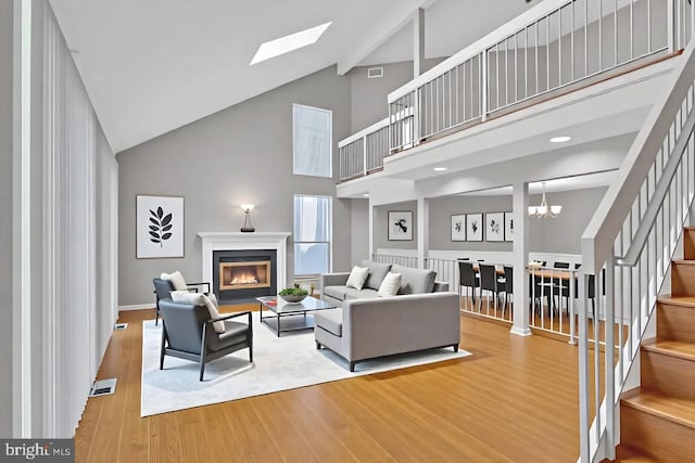 22 Witch Hazel Ct, Monmouth Junction, NJ 08852 - living area featuring high vaulted ceiling, stairs, wood finished floors, a glass covered fireplace, and a skylight