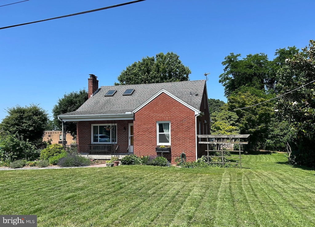 867 Elm St, Bressler, PA 17113 - bungalow with brick siding, a chimney, a front lawn, and covered porch