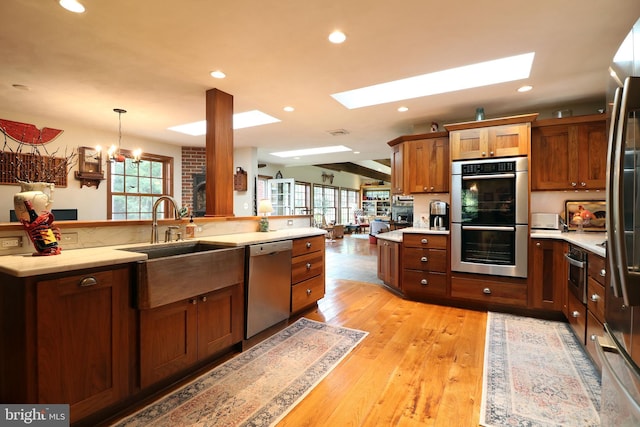 320 Hartswick Ave, State College, PA 16803 - kitchen featuring appliances with stainless steel finishes, a skylight, recessed lighting, hanging light fixtures, and brown cabinets