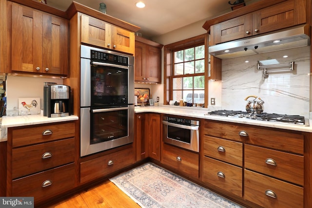 320 Hartswick Ave, State College, PA 16803 - kitchen with appliances with stainless steel finishes, brown cabinets, light countertops, and decorative backsplash