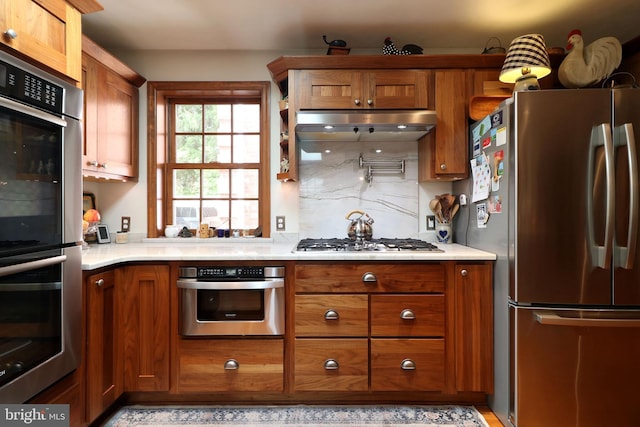 320 Hartswick Ave, State College, PA 16803 - kitchen with stainless steel appliances, brown cabinets, under cabinet range hood, and light countertops
