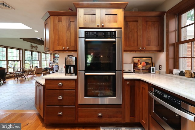 320 Hartswick Ave, State College, PA 16803 - kitchen featuring double oven, brown cabinets, light stone counters, light wood-style floors, and recessed lighting