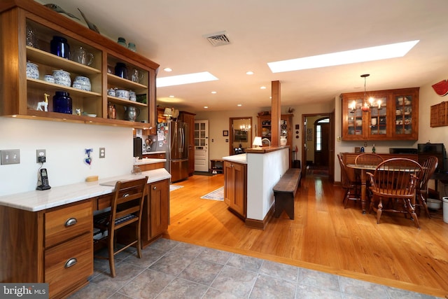 320 Hartswick Ave, State College, PA 16803 - kitchen featuring a skylight, freestanding refrigerator, glass insert cabinets, an office area, and a peninsula