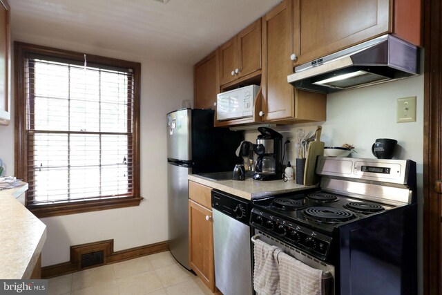 320 Hartswick Ave, State College, PA 16803 - kitchen with appliances with stainless steel finishes, extractor fan, light countertops, and brown cabinetry