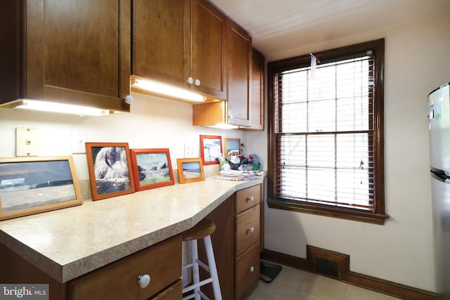 320 Hartswick Ave, State College, PA 16803 - kitchen with built in desk, light tile patterned floors, and light countertops