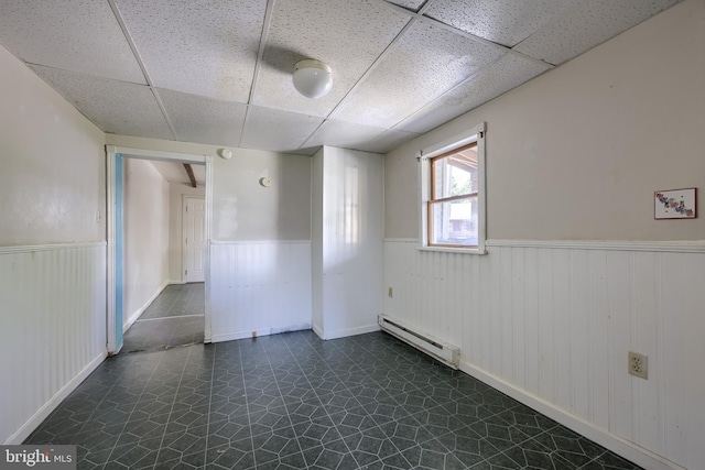 521 Concord Ln, Columbia, PA 17512 - unfurnished room featuring a baseboard heating unit, a wainscoted wall, a drop ceiling, and dark floors