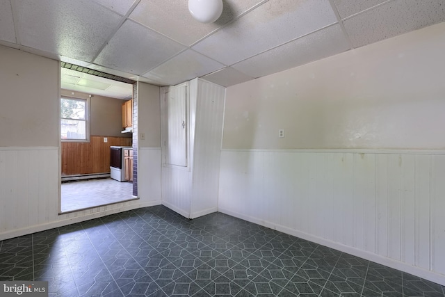 521 Concord Ln, Columbia, PA 17512 - empty room featuring a wainscoted wall, a drop ceiling, baseboard heating, and dark flooring