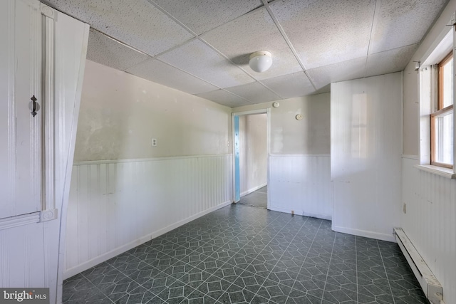 521 Concord Ln, Columbia, PA 17512 - spare room with a baseboard heating unit, a paneled ceiling, wainscoting, and dark floors