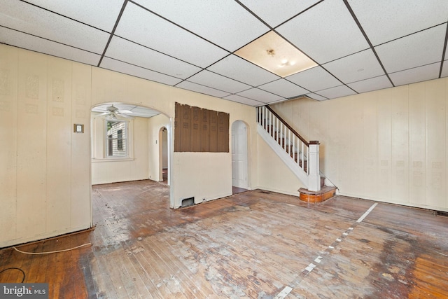 901 Fairview St, Camden, NJ 08104 - unfurnished living room with arched walkways, a paneled ceiling, stairway, and wood-type flooring