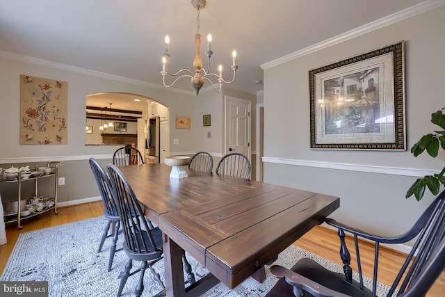 1228 Hunsicker Rd, Lancaster, PA 17601 - dining room featuring arched walkways, light wood finished floors, ornamental molding, and a chandelier
