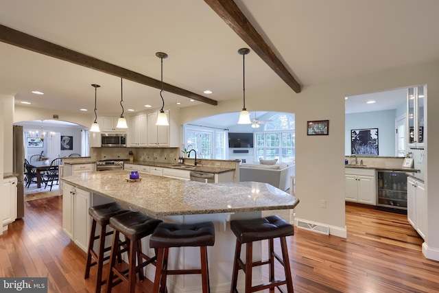 1228 Hunsicker Rd, Lancaster, PA 17601 - kitchen featuring stainless steel appliances, arched walkways, wine cooler, a peninsula, and beamed ceiling