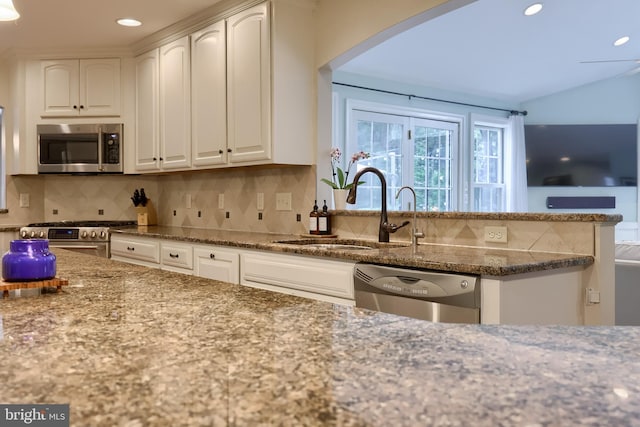 1228 Hunsicker Rd, Lancaster, PA 17601 - kitchen with appliances with stainless steel finishes, dark stone counters, arched walkways, white cabinetry, and tasteful backsplash