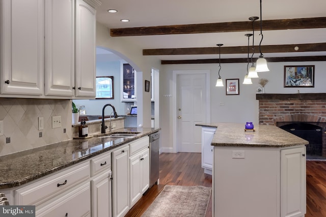 1228 Hunsicker Rd, Lancaster, PA 17601 - kitchen with arched walkways, beamed ceiling, dark wood-style floors, backsplash, and white cabinetry