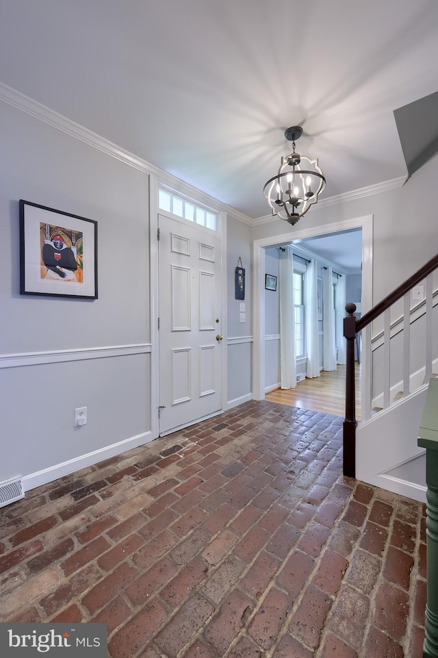 1228 Hunsicker Rd, Lancaster, PA 17601 - entryway featuring a chandelier, ornamental molding, brick flooring, and stairs