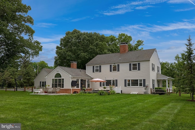 1228 Hunsicker Rd, Lancaster, PA 17601 - back of house featuring a chimney, a lawn, and a patio