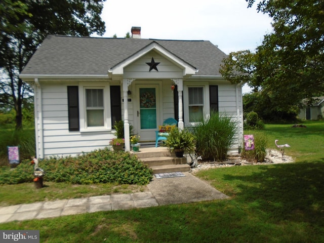 60 Branson Cove Rd, Hague, VA 22469 - bungalow-style house with a shingled roof, a front yard, and a chimney