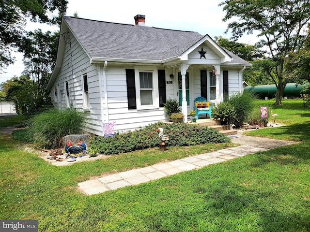 60 Branson Cove Rd, Hague, VA 22469 - bungalow-style house with a chimney, a front yard, a shingled roof, and a porch