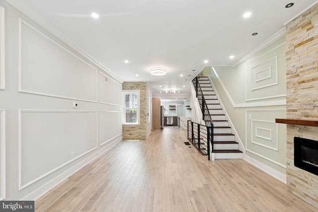 2106 E Somerset St, Philadelphia, PA 19134 - unfurnished living room with a stone fireplace, ornamental molding, wood finished floors, stairs, and recessed lighting
