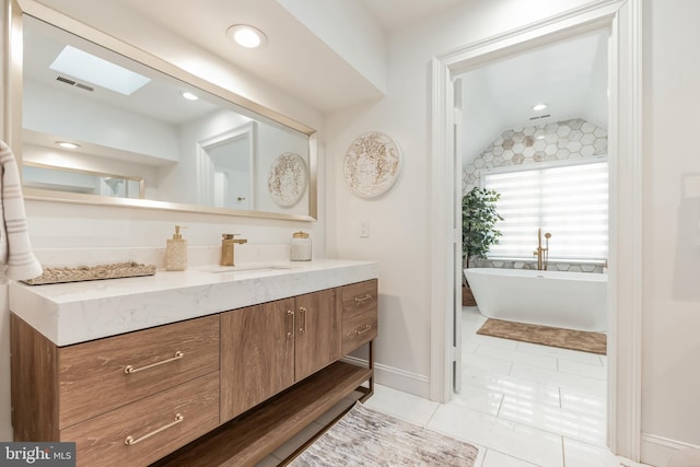10513 Democracy Ln, Potomac, MD 20854 - full bath with vaulted ceiling, vanity, a freestanding bath, tile patterned floors, and recessed lighting