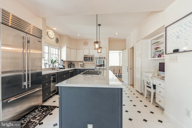 10513 Democracy Ln, Potomac, MD 20854 - kitchen featuring appliances with stainless steel finishes, wine cooler, light countertops, hanging light fixtures, and a center island