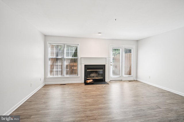 450 Hartford Sq Unit 7, West Chester, PA 19380 - unfurnished living room featuring plenty of natural light, a glass covered fireplace, and wood finished floors