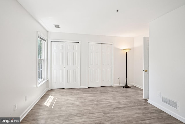 450 Hartford Sq Unit 7, West Chester, PA 19380 - unfurnished bedroom with two closets and wood finished floors
